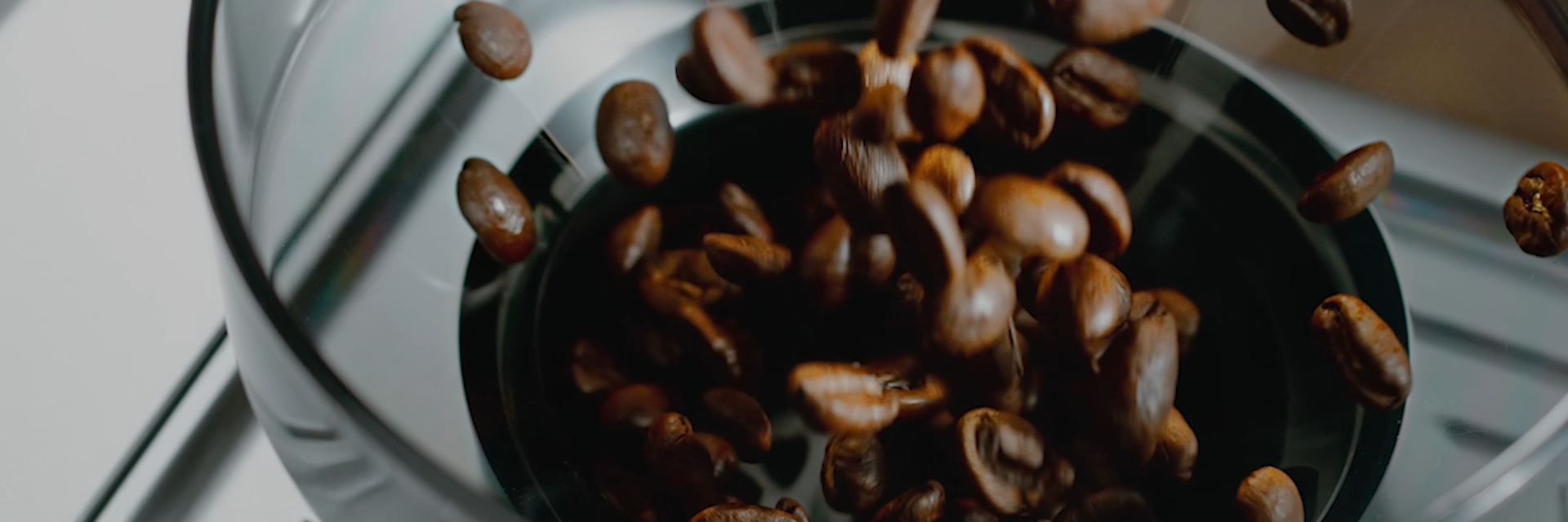 Koffiebonen vallen in de maalbeker van een Ariete koffiemolen